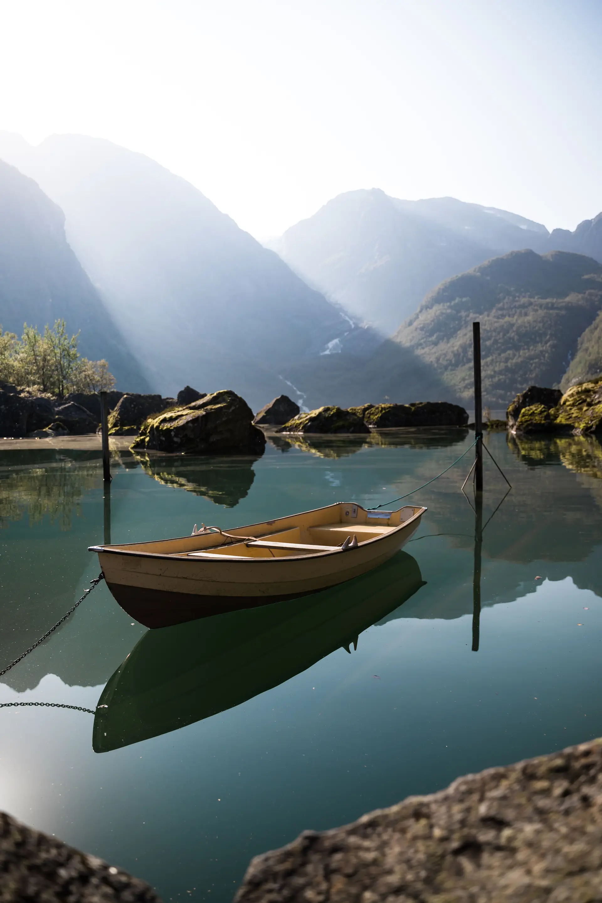 Fredfull fjord med fjellrefleksjon i kveldssol i Norge