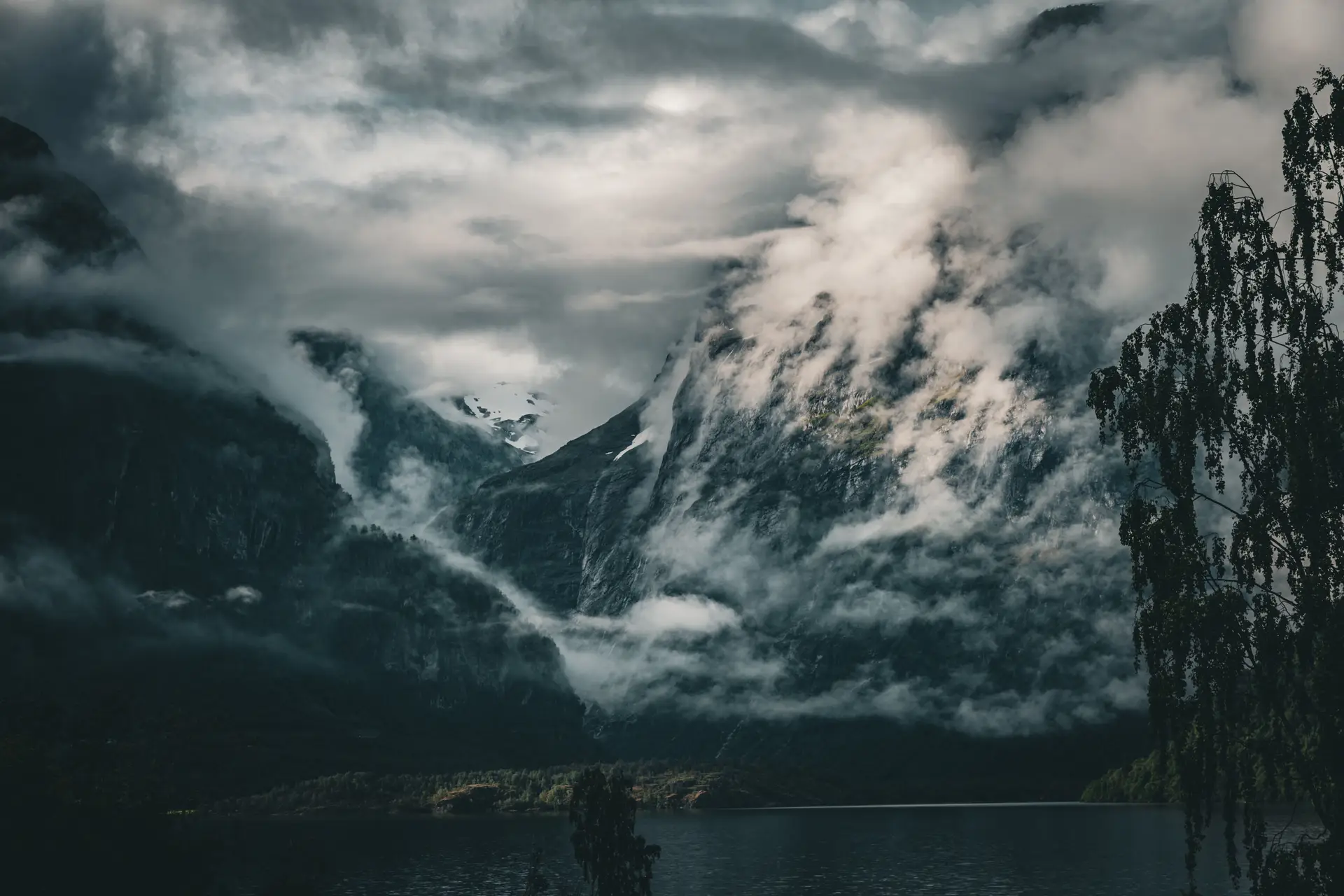 Mektig norsk fjellandskap i skumringen med tåke over vannet